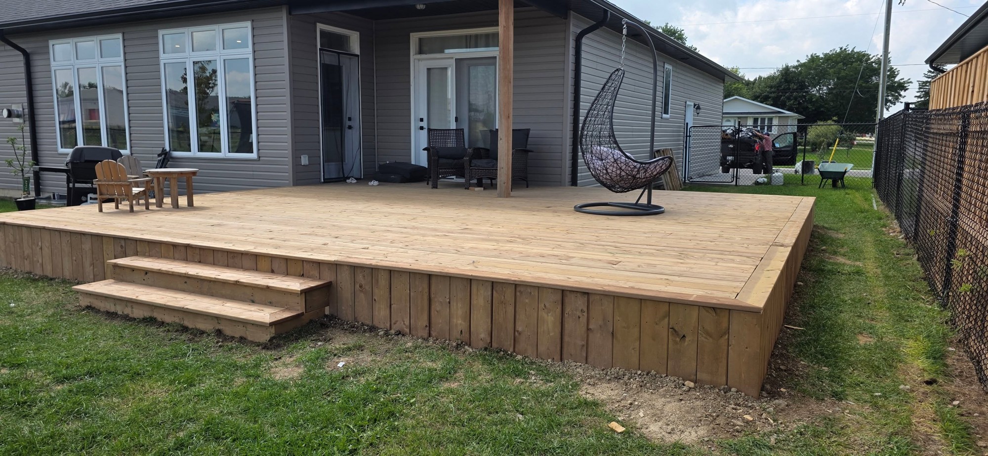 Finished backyard wood deck with wide steps by B&M Mourad Group Inc.